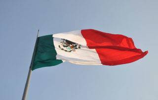 Looking up a flag pole at the Mexican flag