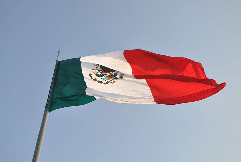 Looking up a flag pole at the Mexican flag